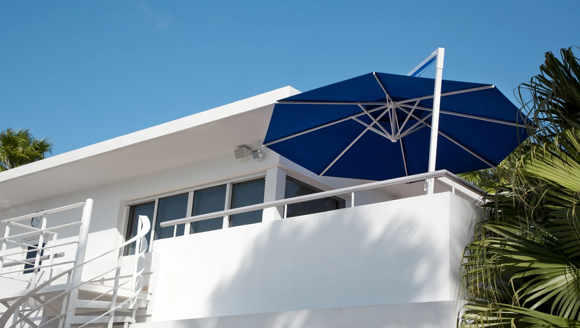 Moderne Villa mit blauem Sonnenschirm auf dem Balkon